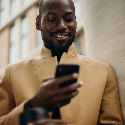 Man on mobile in camel coat looking down_1024x1024