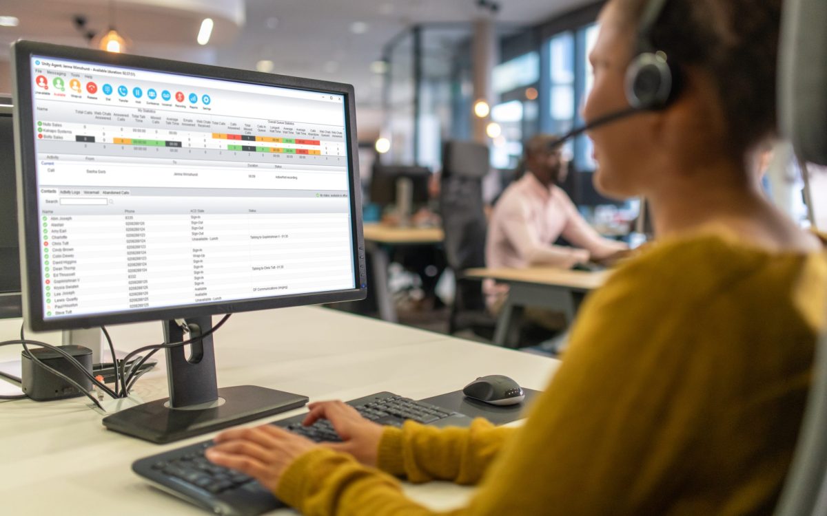 Over-the shoulder view of a woman working in a call center for IT support.