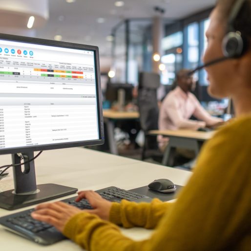 Over-the shoulder view of a woman working in a call center for IT support.